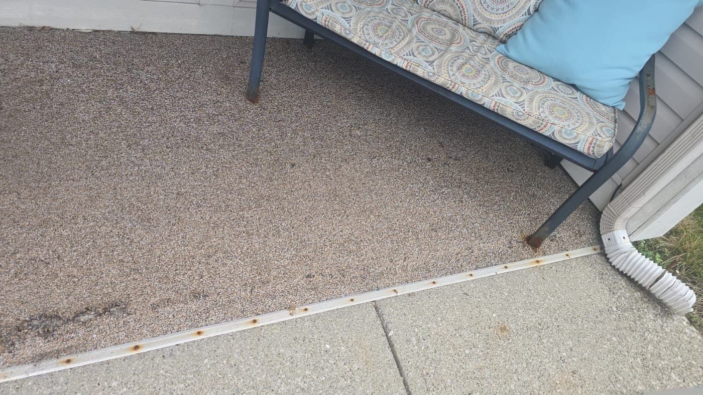 Entry slab with a peeling aggregate coating and a rusted edge strip