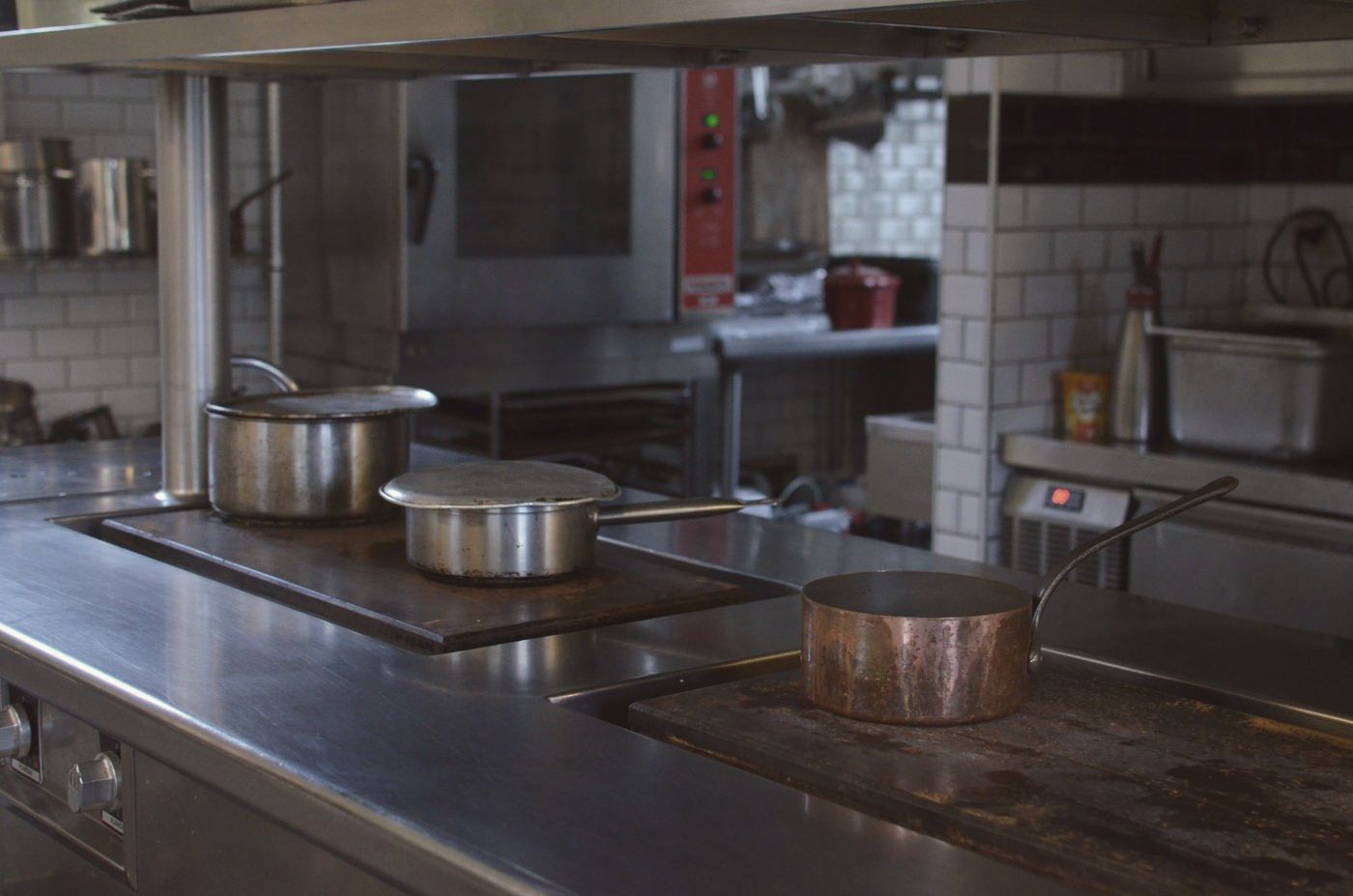 Stainless steel commercial kitchen line with pans on the range